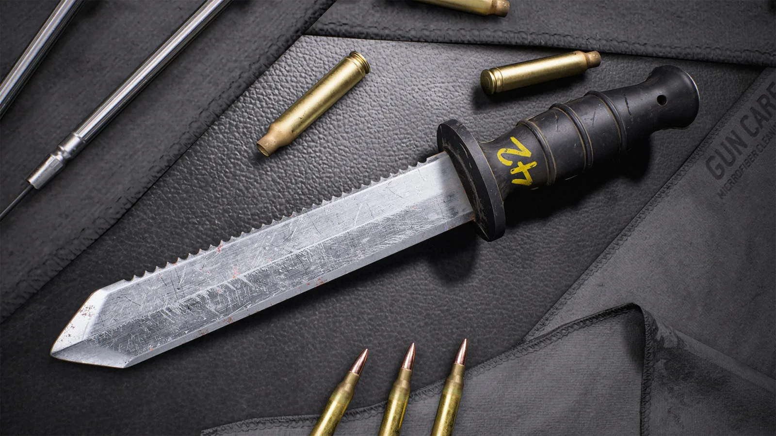Close-up of the Royal Navy Dive Knife, a large partially serrated blade on a workbench beside rifle cartridges