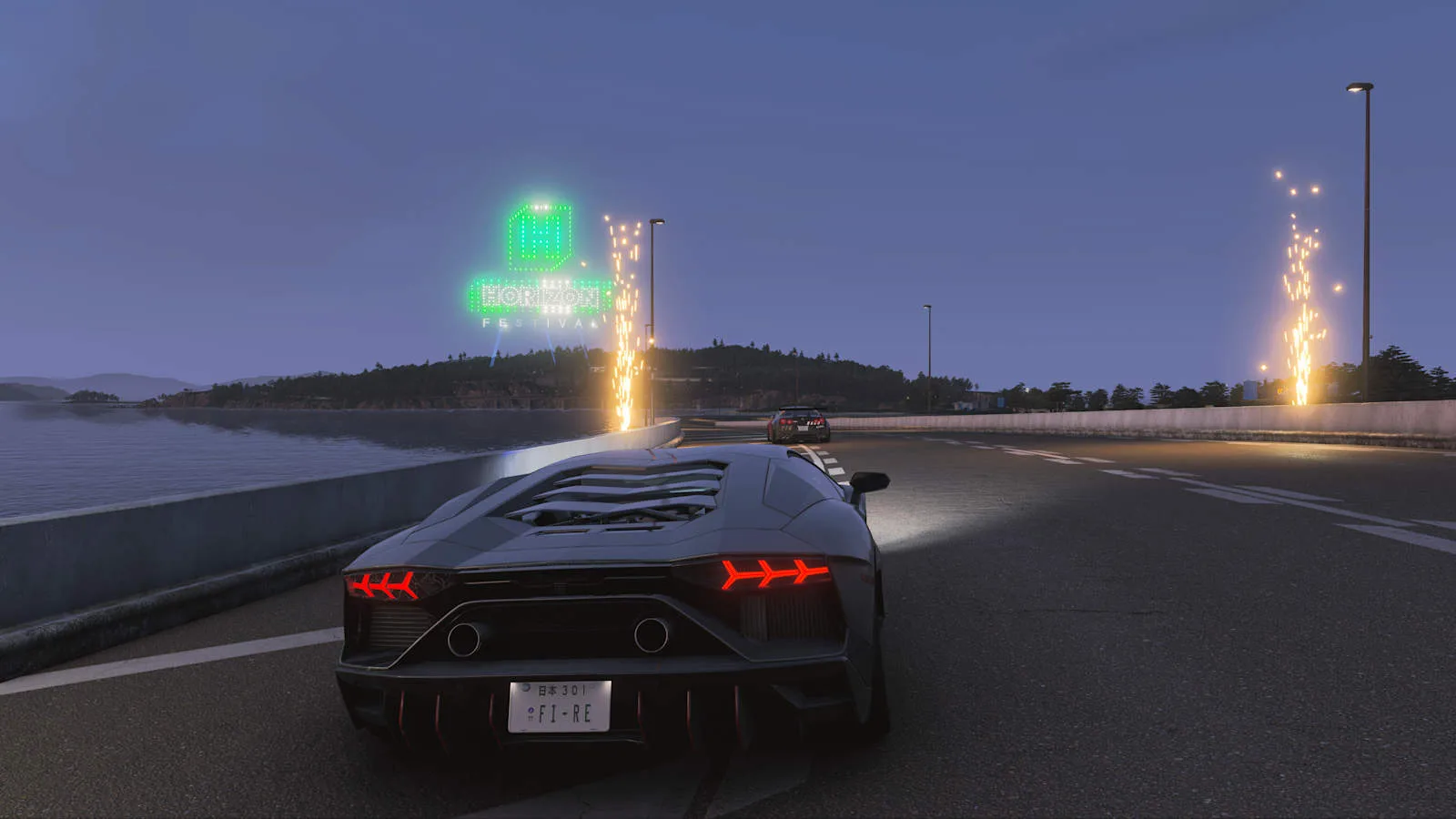 A Lamborghini on a coastal motorway at dusk with the Horizon Festival sign lit up in the distance in Forza Horizon 6
