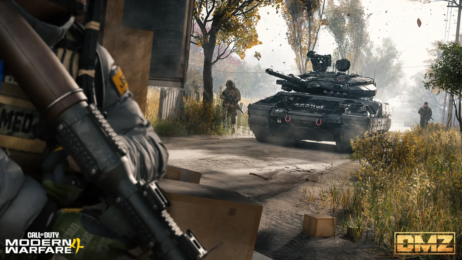 A tank rolling down a rural road in Hajin with infantry beside it
