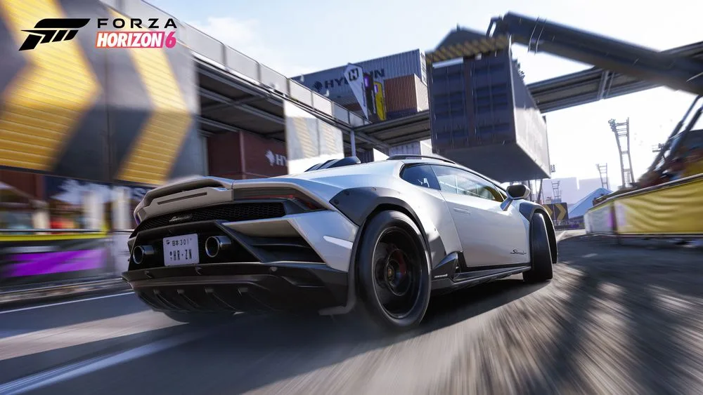 A white Lamborghini Huracan Sterrato speeding through a Horizon Rush course at a container dock in Forza Horizon 6
