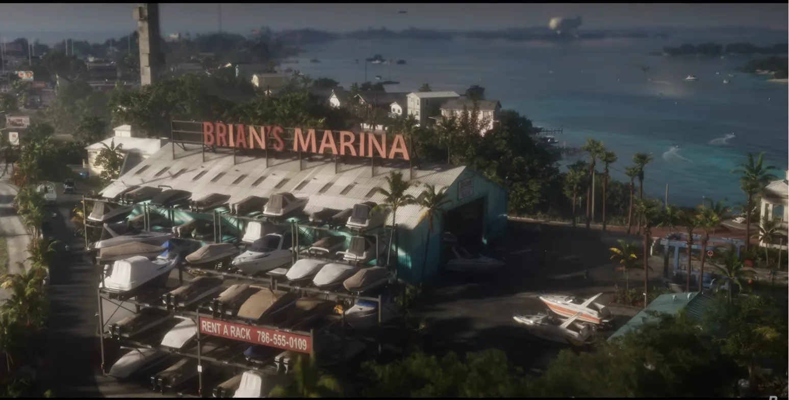 Aerial view of Brian's Marina, a boat storage shed with racks of boats, a Rent a Rack banner and the sea behind with a blimp in the sky