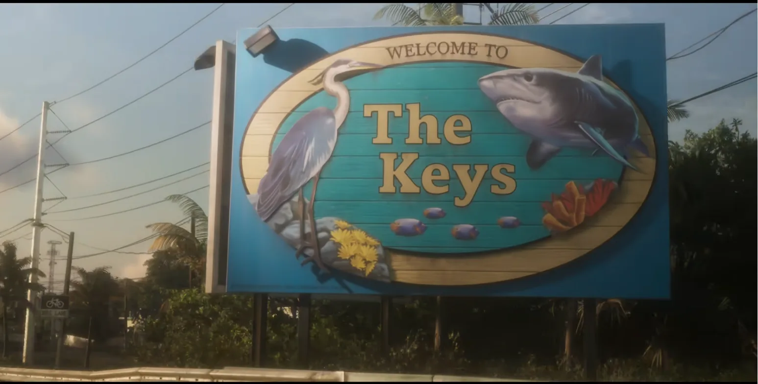 Roadside billboard reading Welcome to The Keys, with a heron, a shark and tropical fish