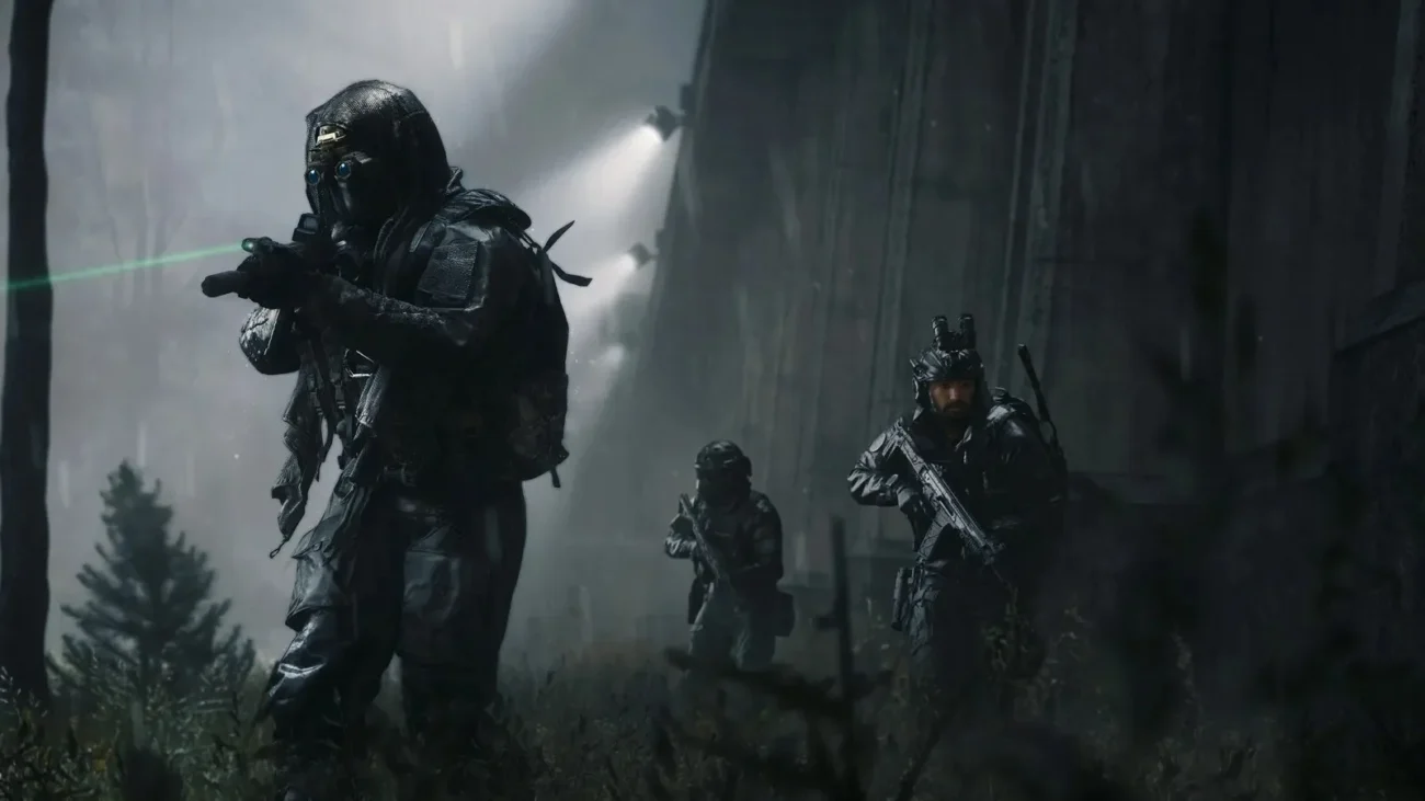 Three Modern Warfare 4 operators advancing through a dark rainy forest, the lead one aiming a rifle with a green laser