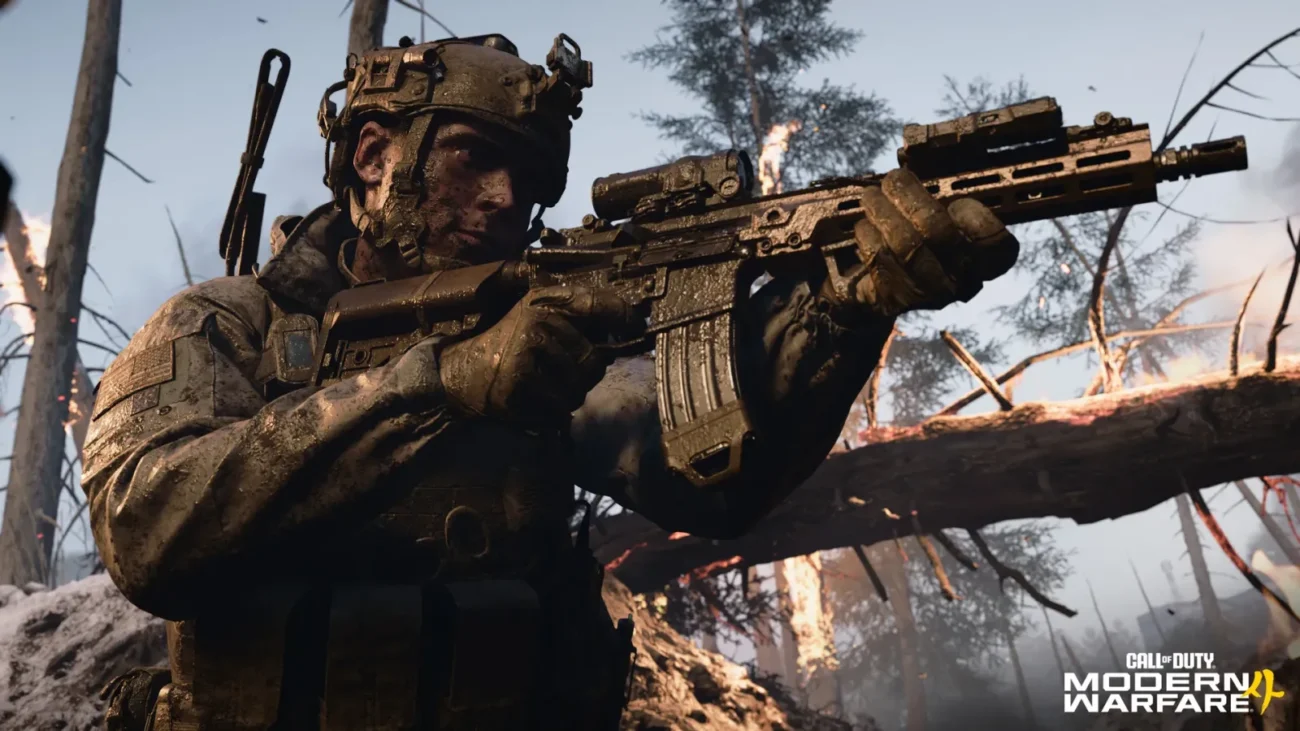 A Modern Warfare 4 soldier aiming a rifle in a muddy, burning forest