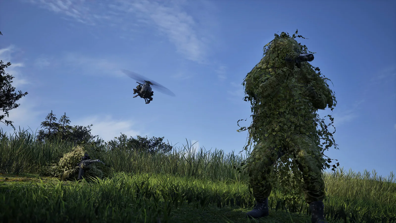 A Wardogs soldier in a ghillie suit spotting with binoculars while a second sniper lies prone in tall grass and a Little Bird helicopter flies overhead